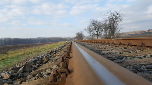 Surface level on railroad tracks on field against sky