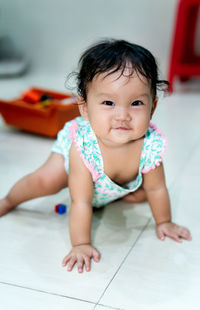 Portrait of cute baby boy on floor