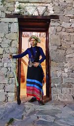 Full length of woman standing against building