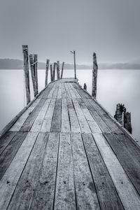 Wooden pier over sea against sky