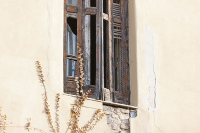 Low angle view of window on wall of old building