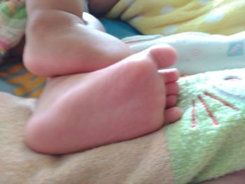 Low section of baby feet on bed