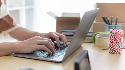 Midsection of woman using laptop on table