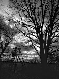 Silhouette bare tree on field against sky