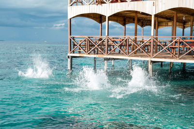 Sea water splashes after jumping to the ocean on light green ripples background.