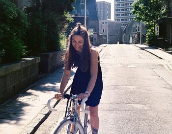 Young woman riding bicycle on road