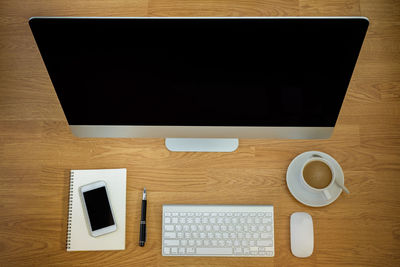 High angle view of coffee and laptop on table