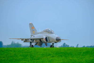 Airplane on field against clear sky