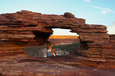 Back portrait at natural red rock window with spectacular views in kalbarri national park