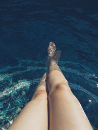 Low section of young woman in swimming pool