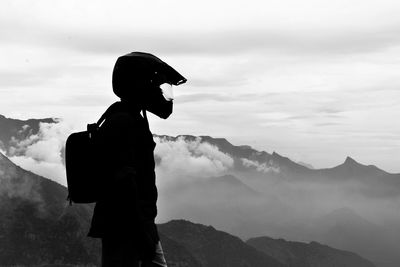 Side view of man standing against mountain