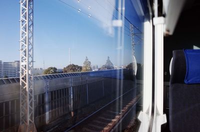 Railroad tracks against clear sky seen through train window