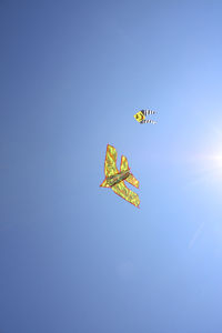 Low angle view of kite against clear blue sky