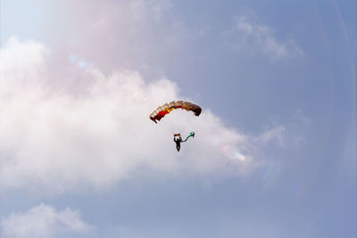 Low angle view of person paragliding against sky