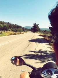 Close-up of sunglasses on road against clear sky