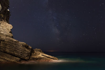 Scenic view of sea against star field at night