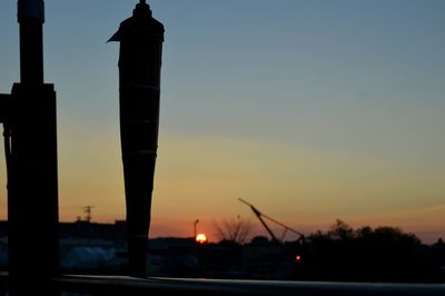 Silhouette city against sky during sunset