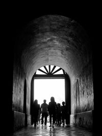 Rear view of people walking in corridor of building