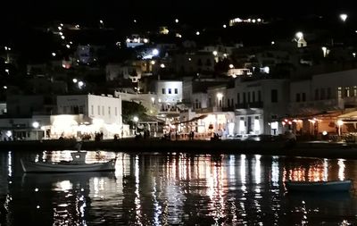 Illuminated buildings by sea at night