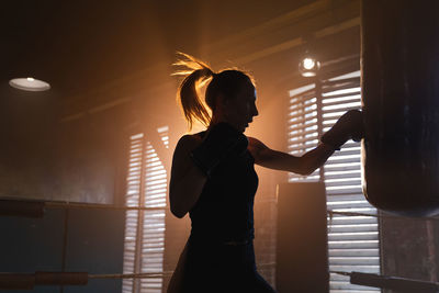 Rear view of woman standing against wall