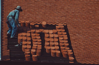 Full length of worker on house roof