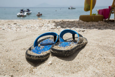 Blue slippers on the beach against the background of the sea