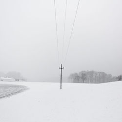 Scenic view of snow covered field against sky