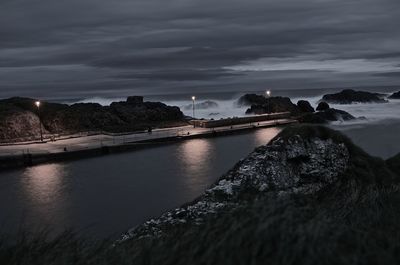 Scenic view of river against cloudy sky