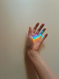 Close-up of human hand against wall