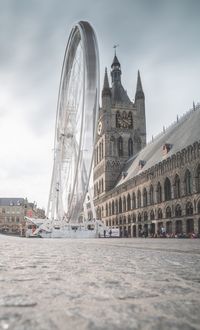 Ferris wheel in city against sky