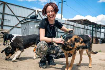 Dog at the shelter. animal shelter volunteer takes care of dogs. lonely dogs in cage with volunteer.