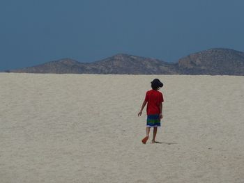 Rear view of a man walking on landscape