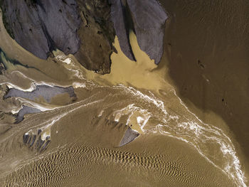 Aerial view of sand by rock formation at desert