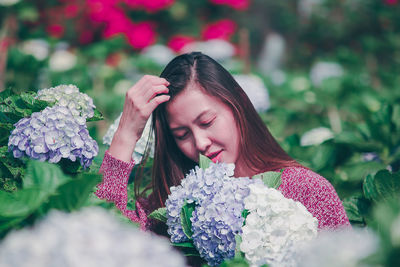 Smiling woman by flowering plants