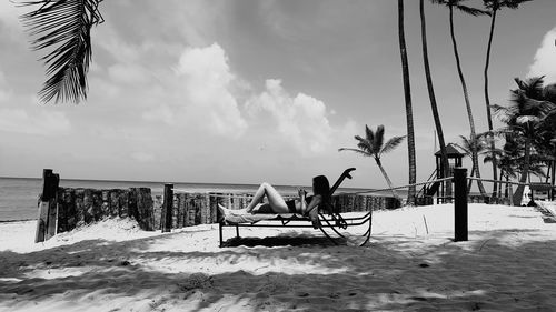 Woman relaxing on lounge chair at beach