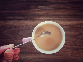 High angle view of hand holding tea cup on table