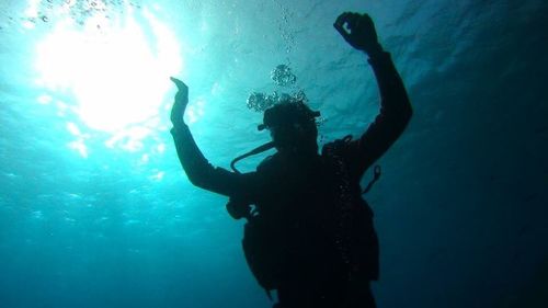 Silhouette man swimming in sea