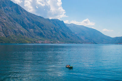 People on boat in sea against sky