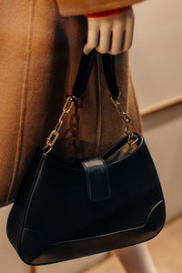 Classic black leather women's handbag with gold chain. fashion details and accessories