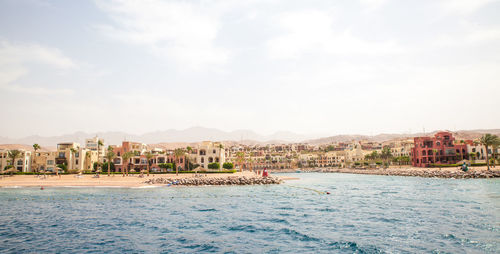 Scenic view of sea and buildings against sky