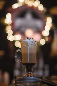 Close-up of drink on jar against illuminated lights