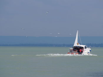 Boat sailing on sea against clear sky