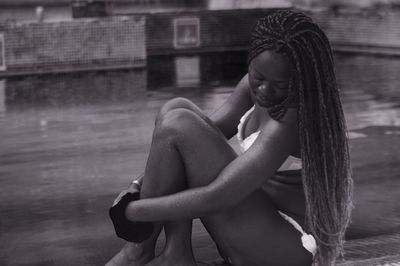 Young woman sitting poolside