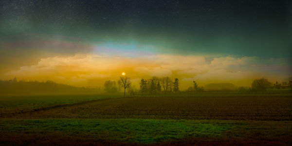 Scenic view of field against sky during sunset