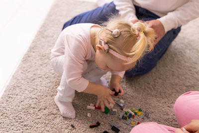High angle view of girl playing with toys on floor