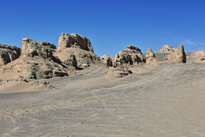 Rock formations in desert against clear blue sky