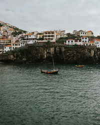 View of townscape by sea against sky