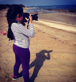 Full length of man photographing on beach