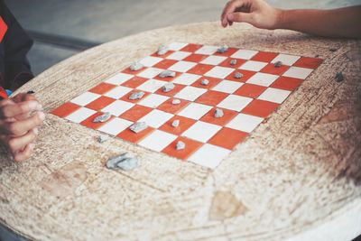 Cropped hands of friends playing board game on table