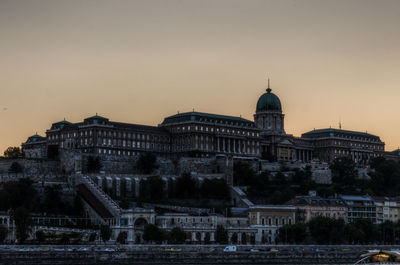 Buildings against sky during sunset in city